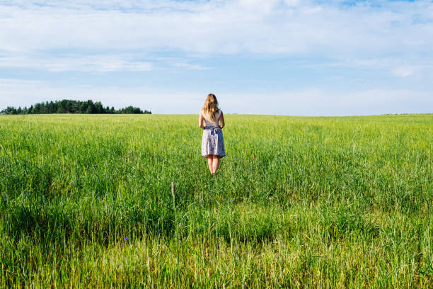 istock Young woman on a wheat field with sunlight 1198273841