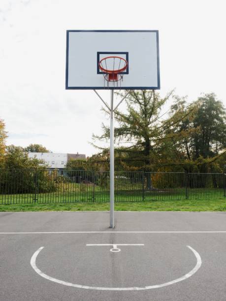 istock Basketball hoop and a cage with poor asphalt 1198275240