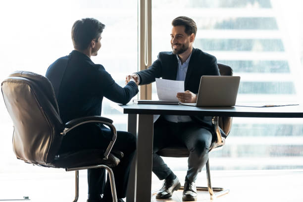 istock Smiling male partners shake hands greeting at briefing 1198278173