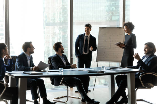 istock Multiracial speakers present project on flip chart to employees 1198278219