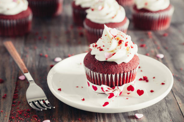 Valentines red velvet cupcakes on a rustic wooden table