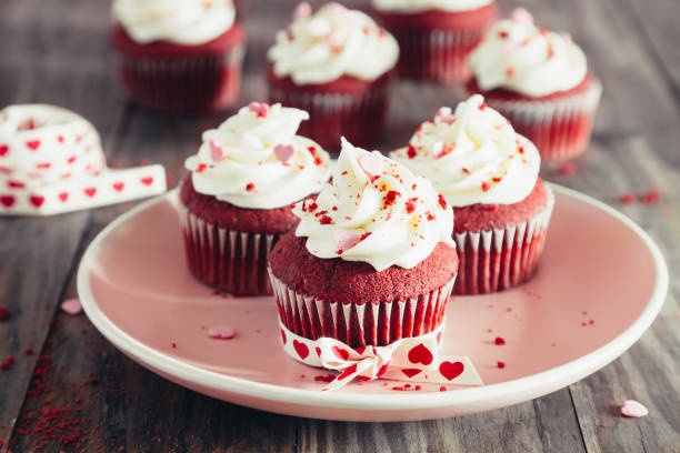 istock Red velvet cupcakes on a pink dish on a rustic wooden table 1198280373