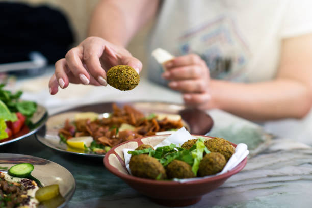 Woman eating falafel in a restaurant Woman eating falafel in a restaurant closeup lebanese culture stock pictures, royalty-free photos & images