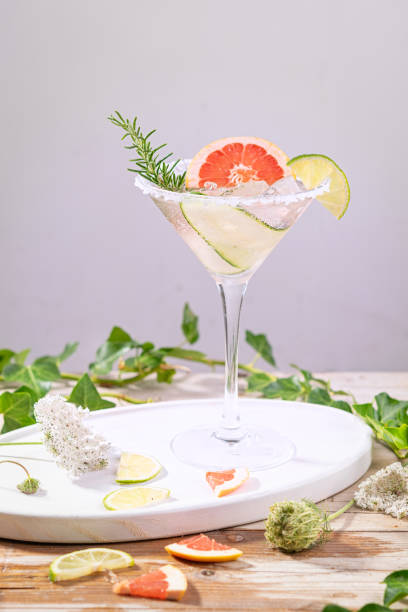 istock Alcohol drink, gin tonic cocktail with grapefruit, cucumber, rosemary, lime, refreshing, cold drinks with ice on a rustic table. Summer garden party, still life with artistic shadows. Copy space. 1198283704