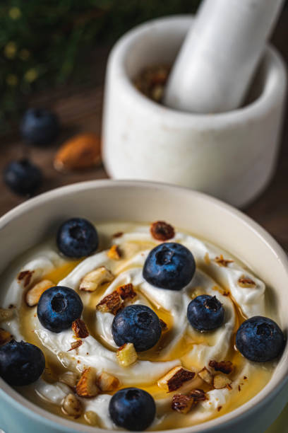 istock Greek yogurt with fresh blueberries, drizzled honey and almonds. 1198286923