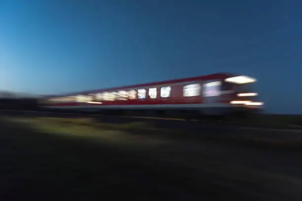 Photo of Train moving at night. Blur motion train. Traveling at night