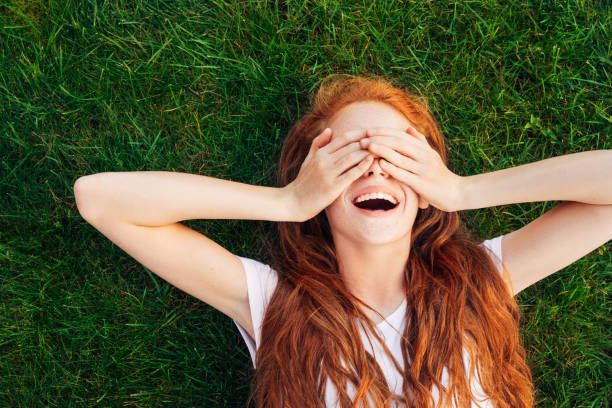 teenage girl laying on the grass - thinking green imagens e fotografias de stock