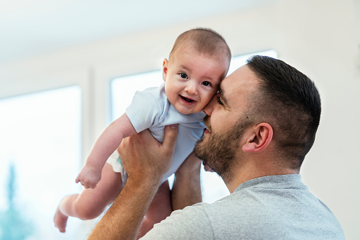 Father and baby boy  playing in bedroom