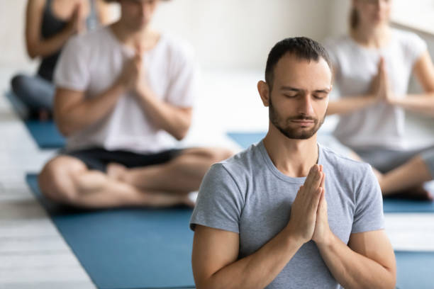 istock Young man meditating at group lesson close up, practicing yoga 1198296936