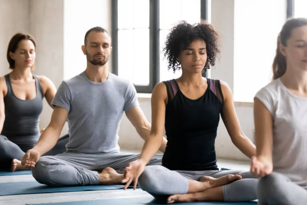 istock Diverse young people meditating, sitting in Lotus pose, practicing yoga 1198296942