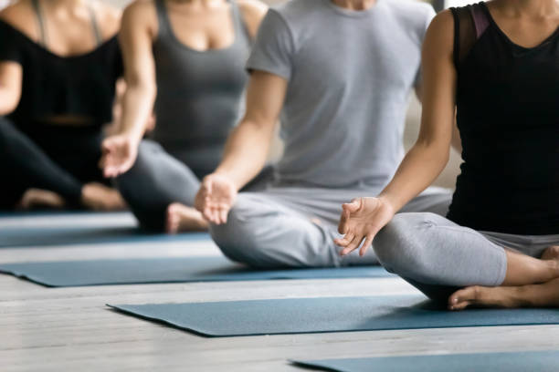 istock Diverse people meditating at group lesson, practicing yoga, Lotus pose 1198296949