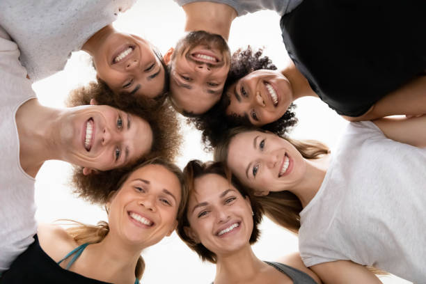 istock Low angle smiling diverse people standing in circle, celebrating success 1198296978