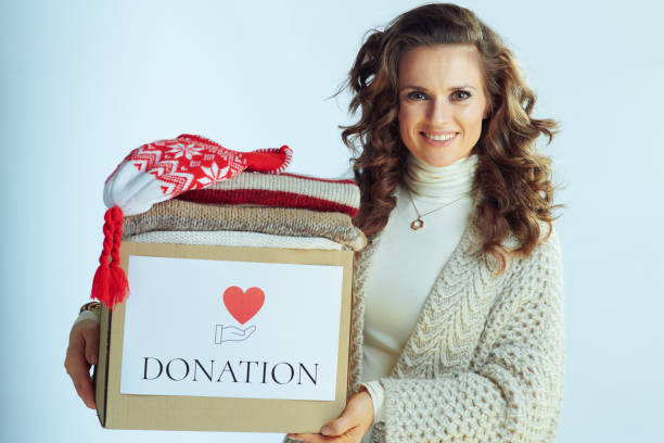 sonriendo moderna mujer sosteniendo caja de donación - humanism fotografías e imágenes de stock