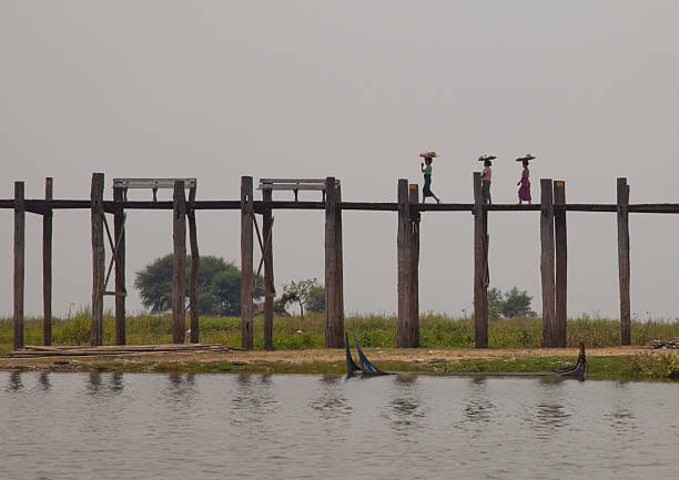 women on a wooden bridge in Myanmar stock photo