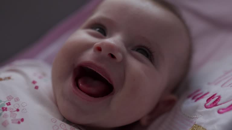 Close-up video of a little baby smiling and laughing