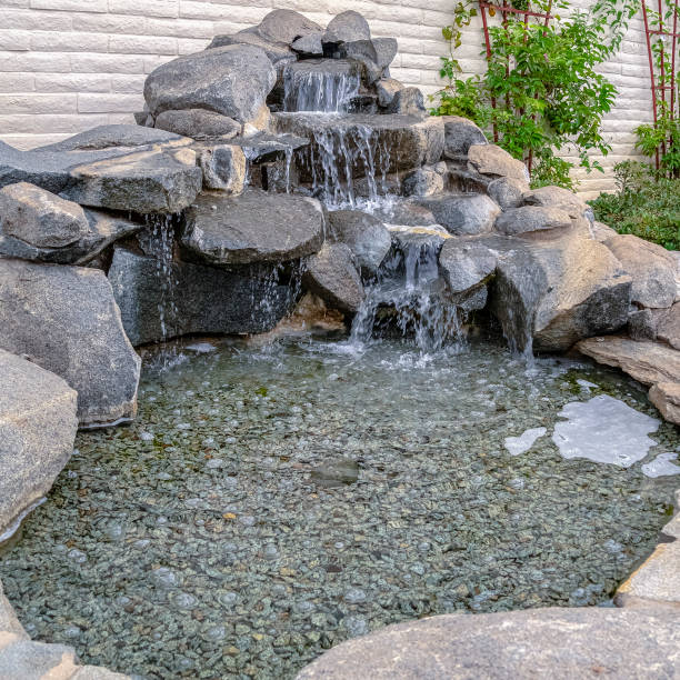 istock Square Outdoor stone decoration with cascade waterfall on a sunny day 1198299954