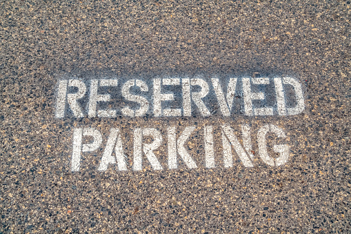 Reserved Parking sign stencilled on tarmac in a close up full frame view from above