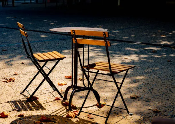 Two bistro chairs and a table in autumn