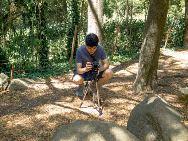 istock Young argentinian photographer taking a picture with a tripod in a forest 1198303829