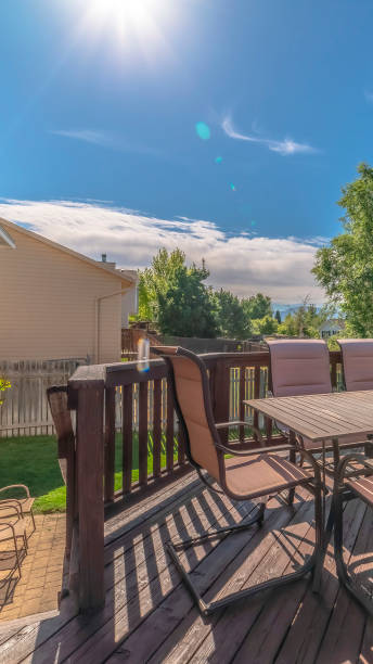 istock Vertical frame Sunlight beaming down on the wooden balcony of a home with table and chairs 1198309309