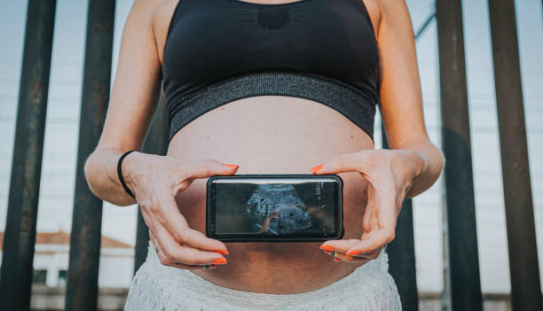 kobieta w ciąży gospodarstwa usg swojego dziecka na telefon komórkowy - human pregnancy telephone ultrasound family zdjęcia i obrazy z banku zdjęć