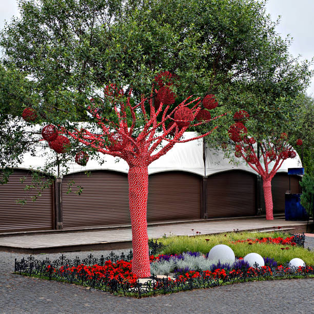 Trees decorated with balls and covered with red cloth with white hearts pattern.