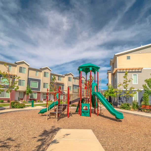istock Square frame Pathway around childrens playground against townhomes and cloudy blue sky 1198313313
