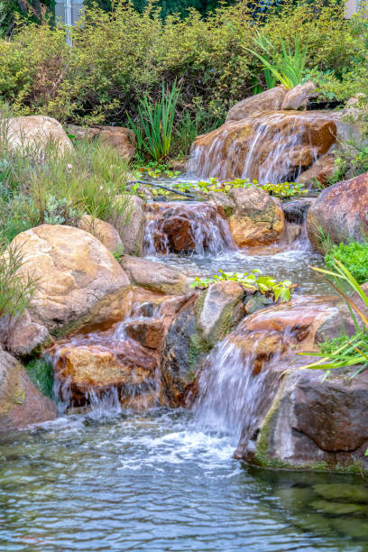 istock Small waterfall cascading over rocks with foliage 1198314107