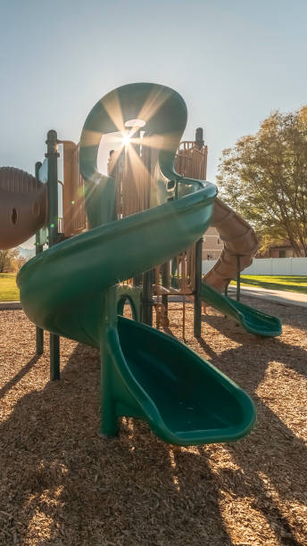 istock Vertical frame Sunburst through equipment on a kids playground 1198314436