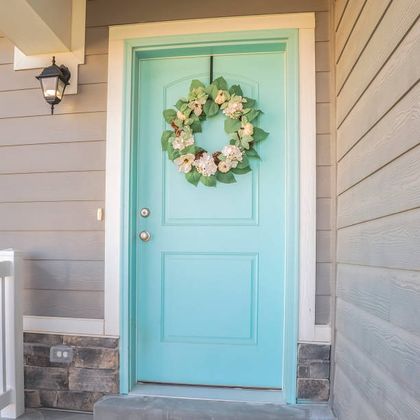 istock Square frame Wooden blue front door with wreath on a sunny day 1198315145