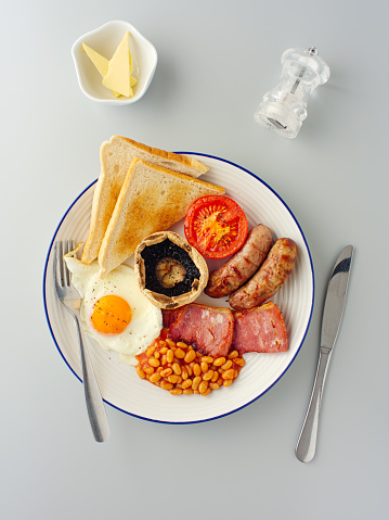 Scrambled eggs with onion and chives served with bread on a blue plate.