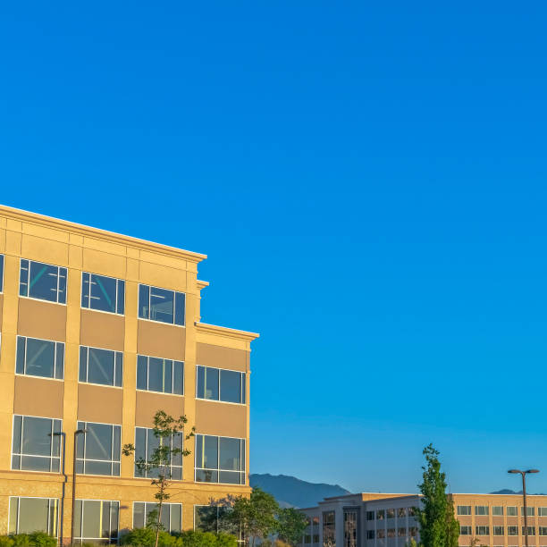 istock Square frame Empty parking lot with buildings mountain and blue sky view on a sunny day 1198320622