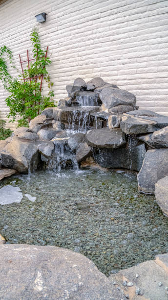 istock Vertical frame Outdoor stone decoration with cascade waterfall on a sunny day 1198320728