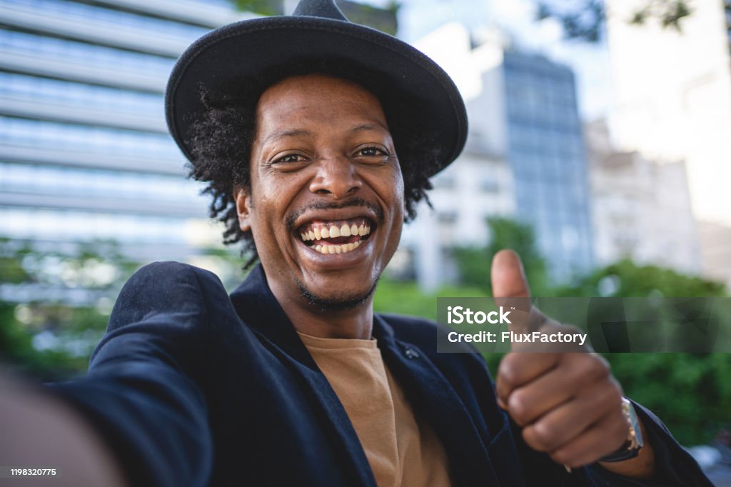 Camera point of view of an African American man holding thumbs up African American man exploring Buenos Aires and taking selfies Men Stock Photo