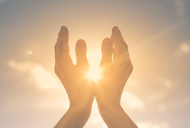 istock Woman hands holding the sun at dawn. 1198320877