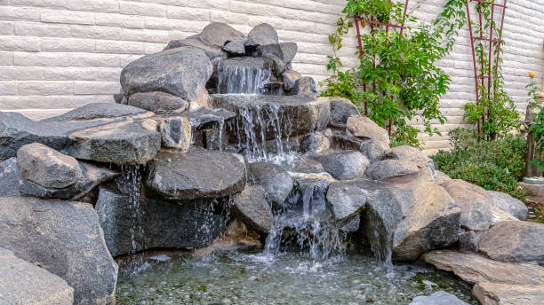 istock Panorama frame Outdoor stone decoration with cascade waterfall on a sunny day 1198320878