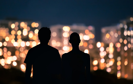 Couple looking at night city lights.