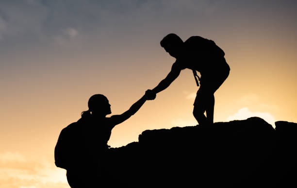 istock Man helping his friend during hike. Helping hikers. 1198321069