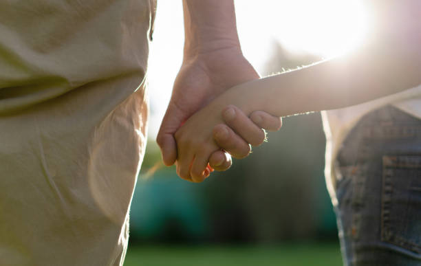 istock Unrecognizable daddy and daughter holding hands on a beautiful sunny day 1198322348