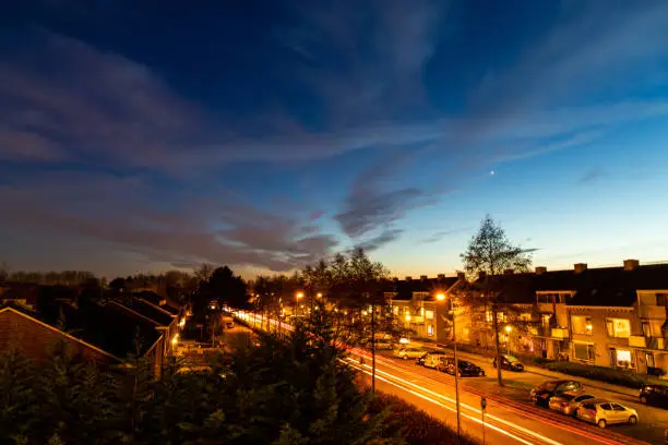 Sunset , dusk and dark with great coloured sky in a town with some moving traffic with lights on low shutter-speed