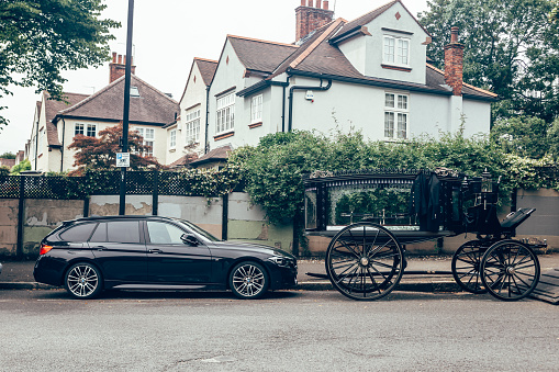 London/UK - 17/07/2019: BMW 3 Series Touring (F31) wagon body style and an old style hearse parked on a side of a street. Concept photo 