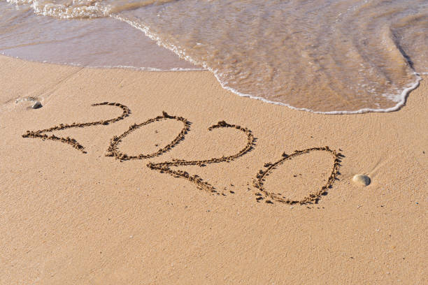 istock Numbers 2020 hand written at sandy seashore beach 1198325329