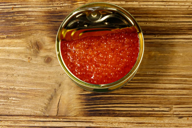 ouvrez la boîte de conserve avec le caviar rouge sur la table en bois. vue du haut - salt pond photos et images de collection