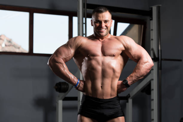 istock Muscular Man Flexing Muscles In Gym 1198326026