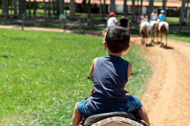 Boy taking a horse ride at the Mazzaropi ranch hotel in Tabate town.