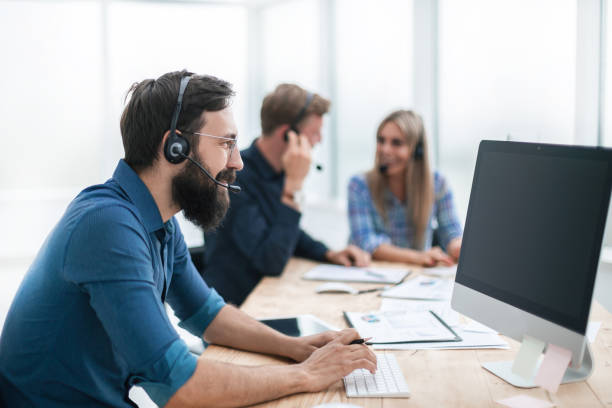 istock business man in a headset sitting at the office table 1198328043