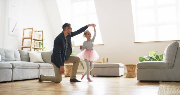 And then we twirl! Shot of a father dancing with his little daughter at home dancing dad stock pictures, royalty-free photos & images