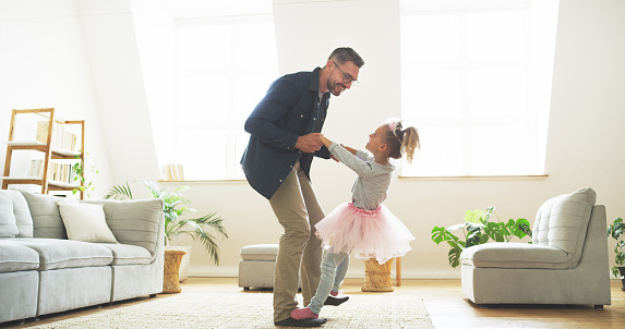 Shot of a father dancing with his little daughter at home