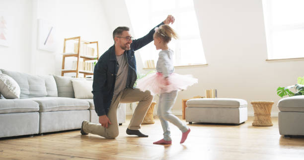 There's never a dull moment when they're together Shot of a father dancing with his little daughter at home dancing dad stock pictures, royalty-free photos & images