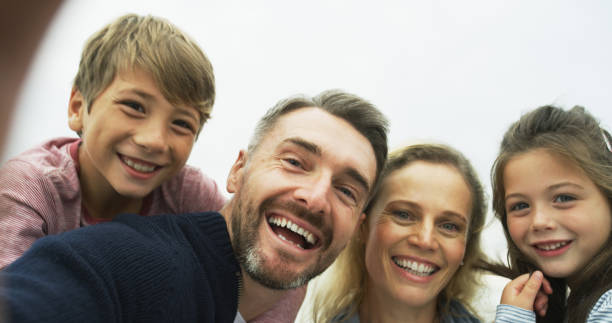 Portrait of a happy family taking selfies together outdoors